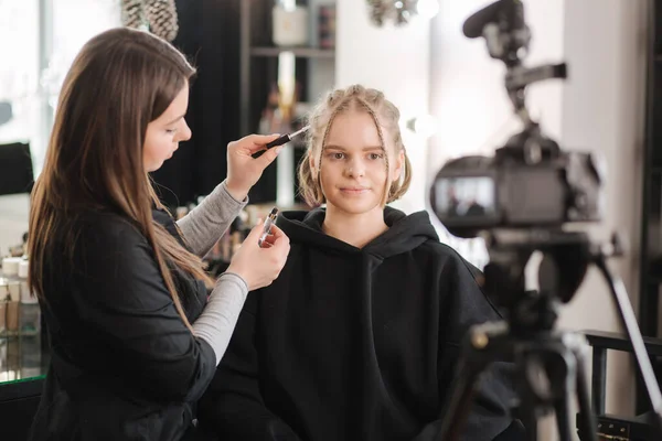 Woman make makeup for attractive blond hair woman in studio. Video of makeup artist applying cosmetics for beautiful model — Stock Photo, Image