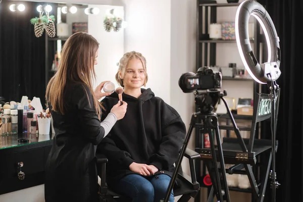 Woman making a video for her blog of making makeup, digital camera on tripod. Young female blogger on camera screen while doing makeup — Stock Photo, Image