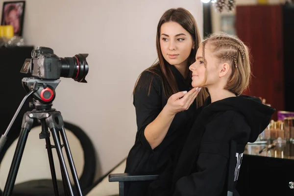 Vista lateral de maquillaje artista trabajo con hermosa modelo de pelo rubio en el estudio hasta que las películas de la cámara proceso de maquillaje. Blog de maquillador — Foto de Stock