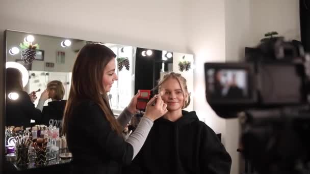 Vrouw maakt een video voor haar blog van het maken van make-up, digitale camera op statief. jong vrouwelijk blogger op camera scherm terwijl het doen van make-up — Stockvideo