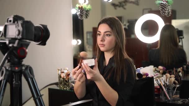 Profesi membuat artis wanita meninjau produk kecantikan di sebuah video blog di studio kecantikan. Wanita menggunakan lampu cincin — Stok Video