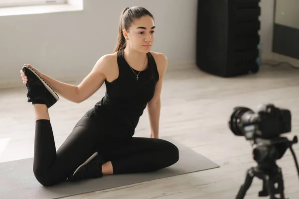 Çekici fitness kadın blogcu dijital kameraya video kaydediyor, stüdyoda eğitim görüyor. Kadın pilates egzersizi yapıyor — Stok fotoğraf