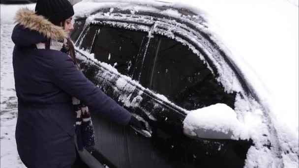 Жінка намагається відкрити машину в мороз. Двері замерзли. Зима — стокове відео