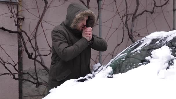 Чоловік бере гомілку з машини і робить снігову кулю — стокове відео