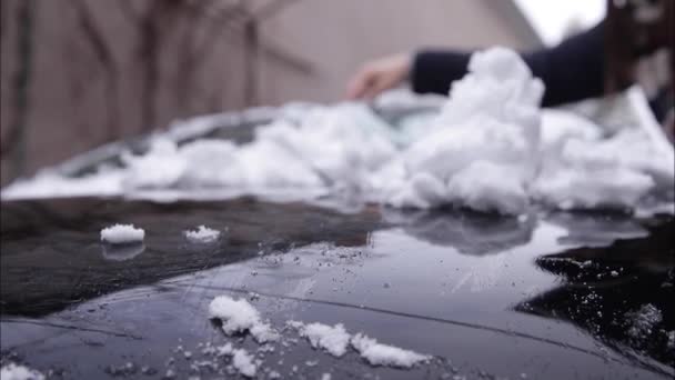 Närbild av människan är rengöring snöiga fönster på en bil med snöskrapa. Fokusera på skrapan. Kall snöig och frostig morgon. Svart bil — Stockvideo