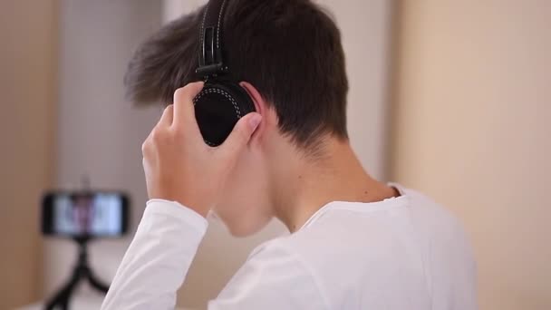 Process of teenage boy puts on headphones befour starting play games. Side view of boy preparing for gaming. Close up — Stock Video