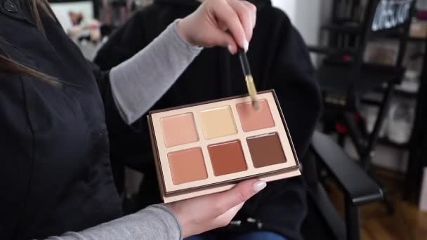 Vrouwelijke make-up artist show met kleur van het palet zal gebruiken. Make-up kunstenaar werk met model in studio — Stockvideo