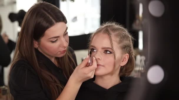 Sidovy av make up konstnärsarbete med vackra blonda hår modell i studio tills kameran filmer processen för makeup. Blogg av makeup artist — Stockvideo