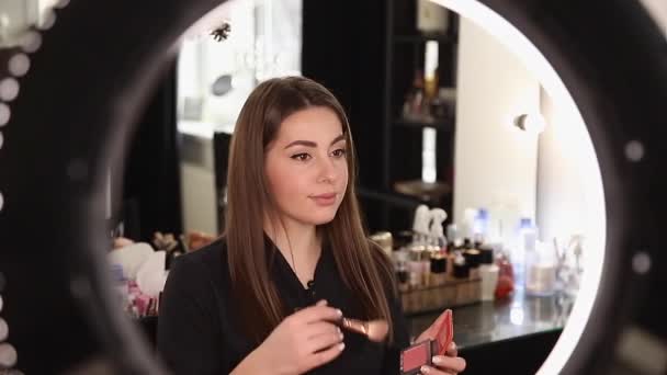 Szakmai alkotó nő felülvizsgálata kozmetikai termékek egy videó blog szépségszalonban. Nő használja gyűrű lámpa — Stock videók