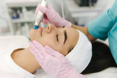 Close-up of woman getting facial hydro microdermabrasion peeling treatment. Female at cosmetic beauty spa slinic. Hydra vacuum cleaner. Cosmetology clipart