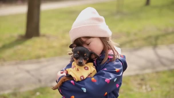 Bella passeggiata bambina con cane carino all'aperto. Sei anni ragazza abbracciare il suo animale domestico — Video Stock