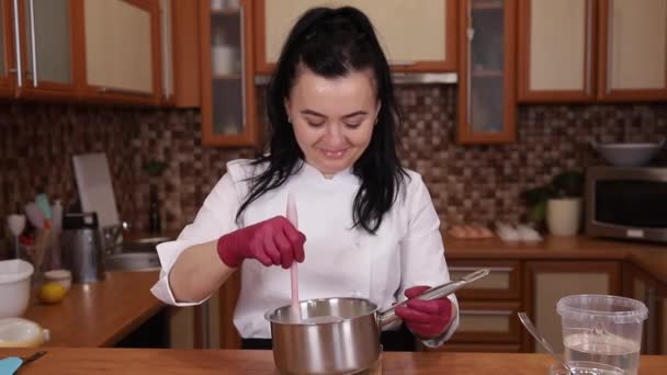 Επαγγελματική γυναίκα ζαχαροπλάστης κάνει κρέμα για κέικ. Γυναίκα μαγειρεύει στην κουζίνα. Διαδικασία για να καταστεί σαφές γάνωμα στο σπίτι. Μαγειρική, μαγειρική έννοια — Αρχείο Βίντεο