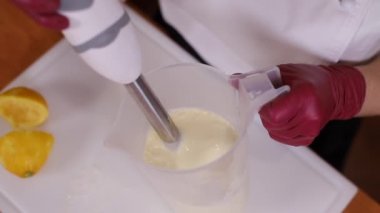 Kadın pasta için krema yapıyor. Geleneksel ev yapımı kek yapma süreci. Karışık malzemeleri karıştırıcı kullanarak yakın plan kadın malzemeleri. Kapat.