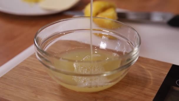 Frauen gießen frischen Zitronensaft in Gläser. Zubereitung von Kuchen zu Hause — Stockvideo