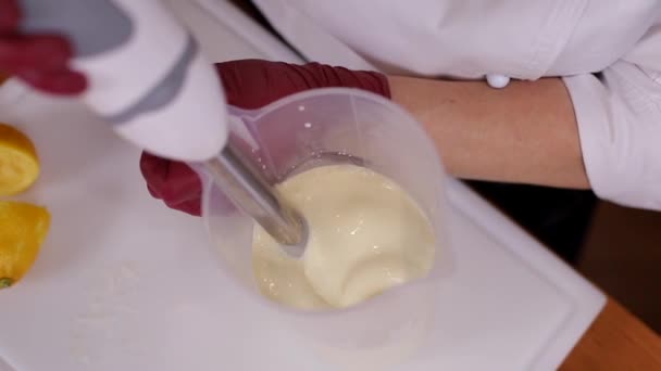 Kvinnan gör grädde till tårta. Process för att göra traditionell hembakad kaka hemma. Närbild av kvinna blandade ingredienser med hjälp av mixer. Närbild — Stockvideo