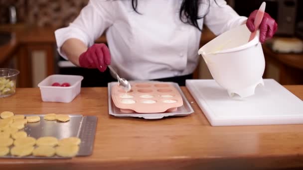 La femme fait de la crème pour gâteau. Processus de fabrication de gâteau maison traditionnel. Gros plan de la femme mettre de la crème dans le moule en silicone — Video