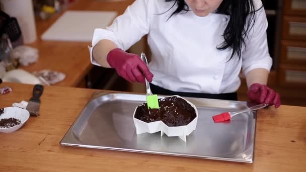 Professionell kvinnlig konditor gör chokladtårta. Kvinnan lagar mat i köket. Framställning av mjölkchoklad hemma. Matlagning, bakning koncept — Stockvideo