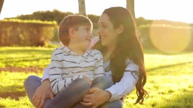 Çekici genç anne gün batımında oğlunu kucaklıyor.