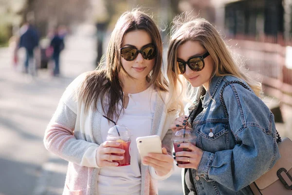 Twee vrouwelijke vriend dring frambozenlimonade en spreken abbout einde quarantaine. Gelukkige vrouw loopt buiten na pandemie — Stockfoto