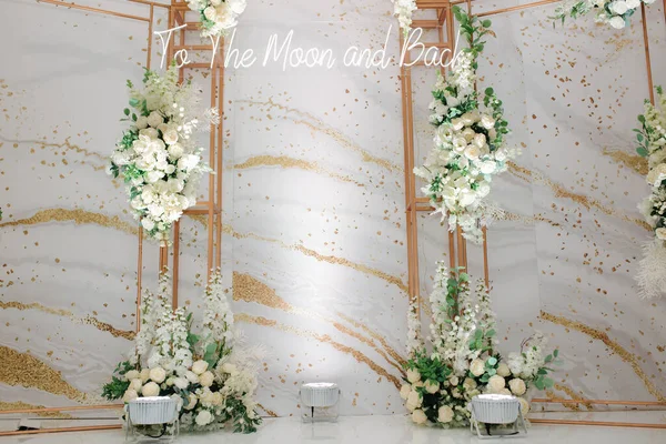 Foto di nozze zona decorata da fiori bianchi e foglie verdi con un'iscrizione, Alla luna e ritorno — Foto Stock
