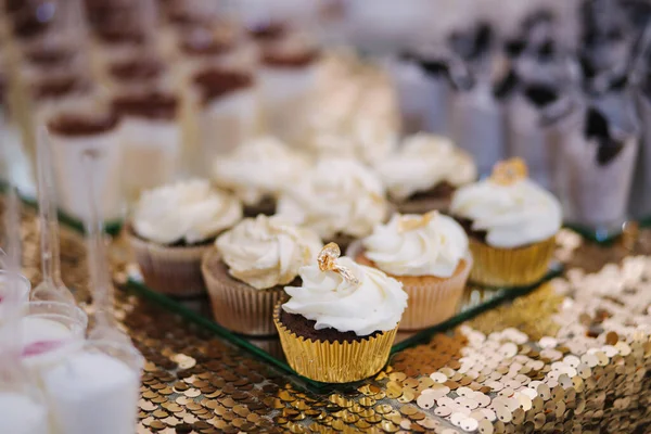 Dort bar na svatbě. Na stole jsou různé sladkosti. Eclair, koláčky, muffiny a mamy další dezerty — Stock fotografie