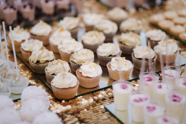 Dort bar na svatbě. Na stole jsou různé sladkosti. Eclair, koláčky, muffiny a mamy další dezerty — Stock fotografie