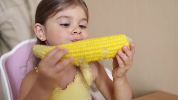 Urocza dziewczynka jedząca kukurydzę w domu. słodkie dziecko drzewo rok stary jeść buduj kukurydzę — Wideo stockowe