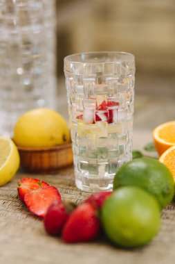 Yaz içeceği. Naneli, buzlu ve çilekli limonata. Masada dilimlenmiş turunçgil