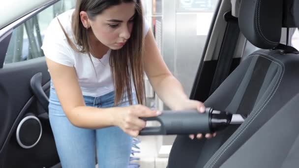 Mulher usando aspirador portátil em seu carro. Vácuo elétrico em mulheres mão carro limpo dentro de poeira. Lavagem de carro auto servise — Vídeo de Stock