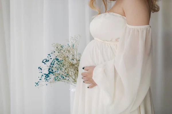 Célection moyenne de la femme enceinte en robe blanche mettre sa main sur le ventre — Photo