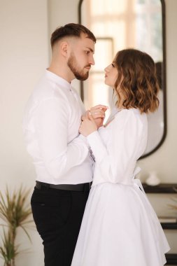 Damat ve gelin birbirlerine yakın dururlar. Adam karısına bakar ve gözlerinin içine bakar.