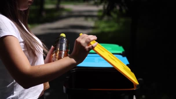 Close-up portret vrouw hand gooien lege plastic fles water in de prullenbak — Stockvideo