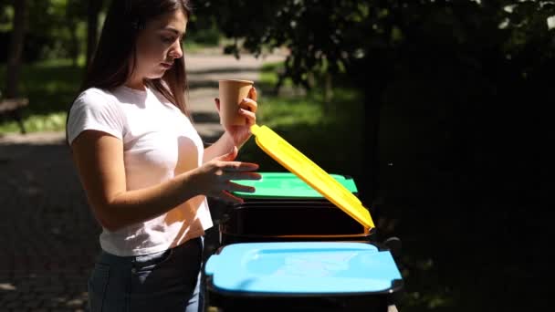 Samice vyhazující do odpadkového koše na jedno použití. Žena samostatné plastové víko s papírovým kelímkem a thow do jiného koše — Stock video