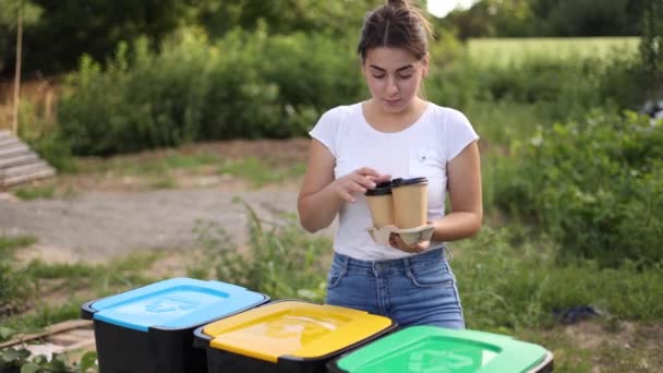 Donna buttare nel cestino del riciclaggio tazza usa e getta. Donna coperchio plactico separato con tazza di cartone e thow in bidone diverso — Video Stock