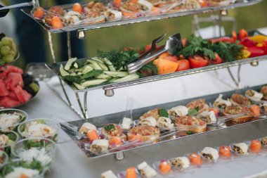 Restorandaki yazlık terasta salatalık ve domates servis edildi. Yemek konsepti. Masada farklı yemek ve içecekler var.