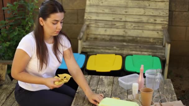 Mujer joven preparando basura para el reciclaje. Diferente color de cubos de basura. Cuidado femenino de la naturaleza y el medio ambiente — Vídeos de Stock