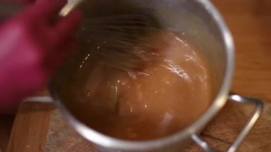 Profesyonel kadın pastacı pasta için krema yapıyor. Kadın mutfakta yemek pişiriyor. Evdeki jöleleri temizleme süreci. Aşçılık, pişirme konsepti