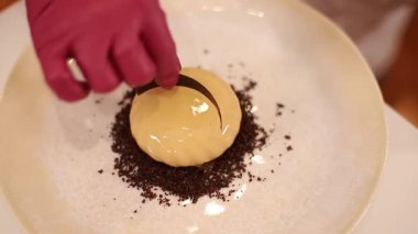 Beyaz Kittel 'deki kadın pastacı mutfakta lezzetli bir tatlı ile süslenmiş. Pembe eldivenli eller, tatlılığı ve çalışmayı tutun.