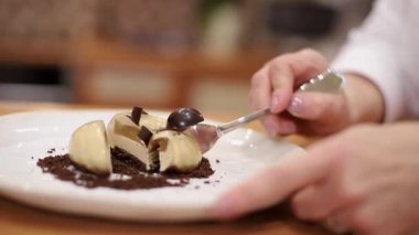 Beyaz Kittel 'deki kadın pastacı mutfakta lezzetli bir tatlı ile süslenmiş. Pembe eldivenli eller, tatlılığı ve çalışmayı tutun.