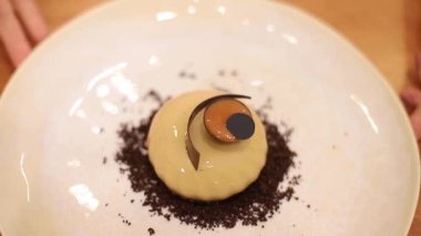 Beyaz Kittel 'deki kadın pastacı mutfakta lezzetli bir tatlı ile süslenmiş. Pembe eldivenli eller, tatlılığı ve çalışmayı tutun.