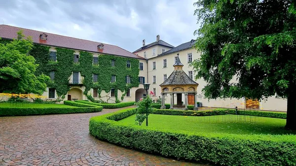 Bressanone, South Tyrol, Italy - June 11, 2024: Picturesque corner of the courtyard of the Augustinian Novacella Abbey with an ancient Renaissance covered well 