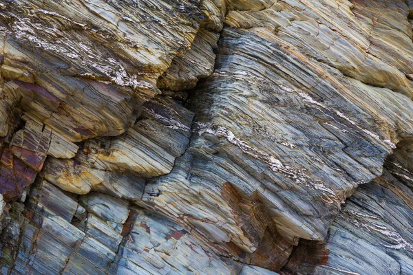 Colored granite and schist rock face — Stock Photo, Image