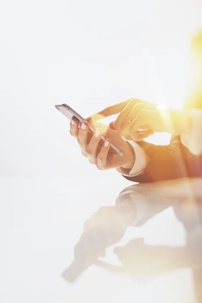 Manos femeninas escribiendo texto en el teléfono inteligente — Foto de Stock