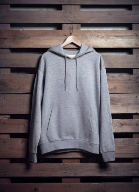 Ahşap arka plan gri hoody tutarak