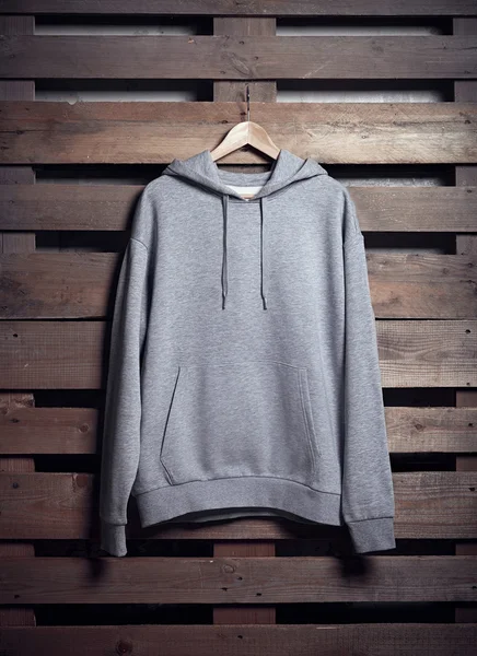Gray hoody holding on wooden background — Stock Photo, Image