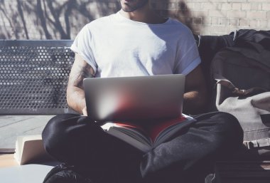 Fotoğraf adam şehir parkı tezgah oturan ve dizüstü kablosuz internet kullanarak. Üniversitede okuyorum, yeni bir proje de çalışıyoruz. Kitap, genel tasarım bilgisayar kullanma. Yatay mock up