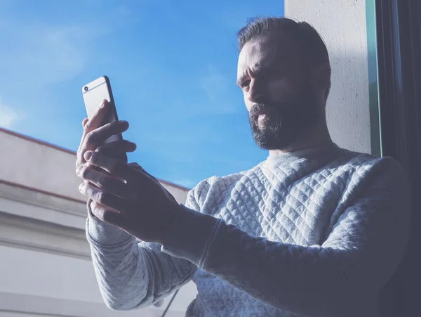 Portre sakallı adam selfie cep telefonu yapıyor. Çağdaş akıllı telefon kullanan bir adam, mavi gökyüzü geçmişi, güneşli bir gün. Yatay, film efekti — Stok fotoğraf