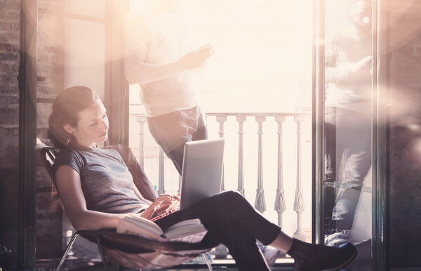 Взрослая пара работает вместе. Фото женщина и бородатый мужчина, работающий с новым стартап-проектом в современном лофте. Использование современных ноутбуков, смартфонов. Горизонтальный, эффект пленки. Размытый фон
