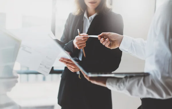 Reunión de socios comerciales de fotografía. Trabajo en equipo. Mujer de negocios dando tarjeta de colega. Presentación nuevo proyecto oficina moderna. Fondo borroso, efecto de película, horizontal — Foto de Stock