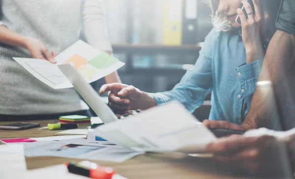 Týmová práce. Foto mladí podnikatelé štáb pracuje s novým startupem projektu. Obecný zápisník na dřevěném stole. Analyzujte plány, klávesnice. Rozmazané pozadí, efekt filmu — Stock fotografie